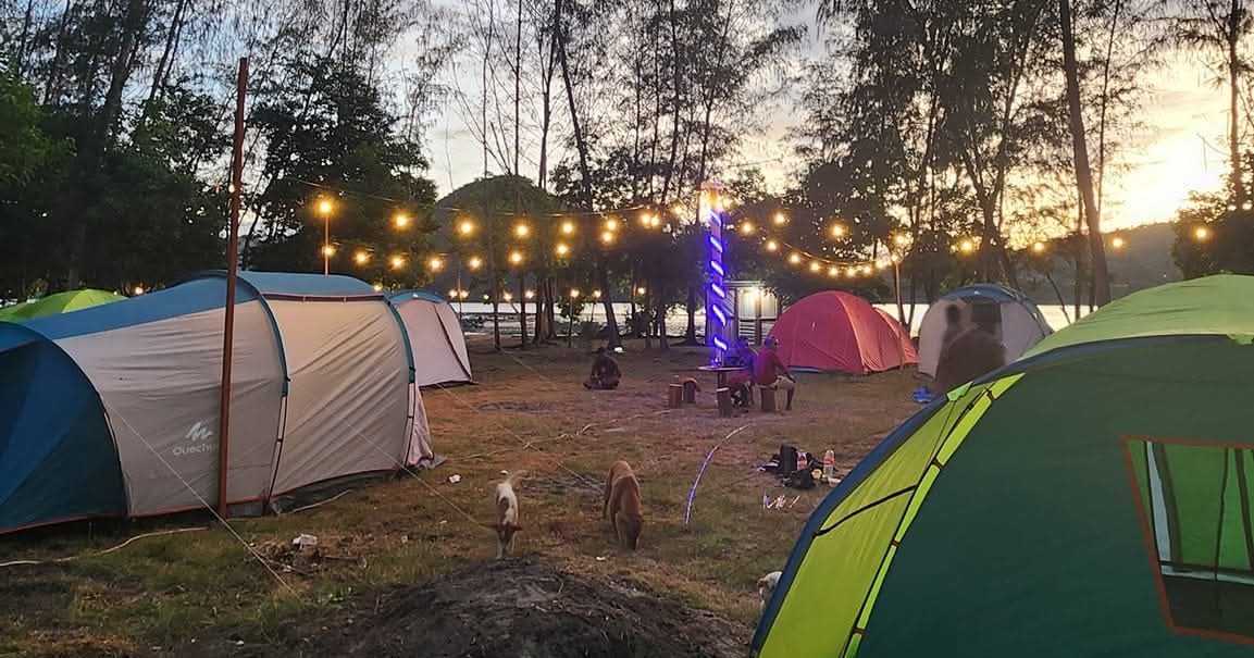 Beberapa tenda di area camping Injros View saat senja dengan lampu gantung