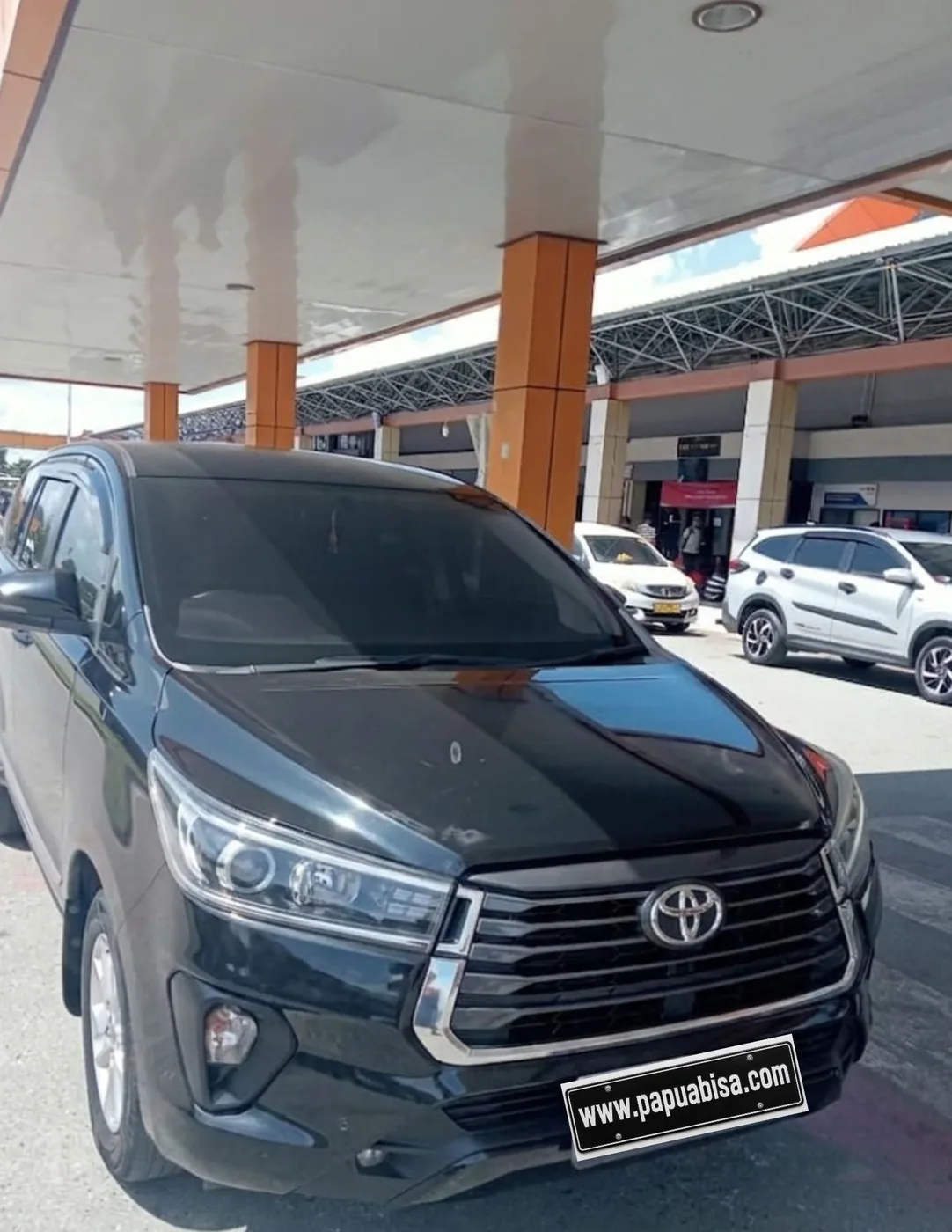 Unit Toyota Innova hitam di area terminal bandara