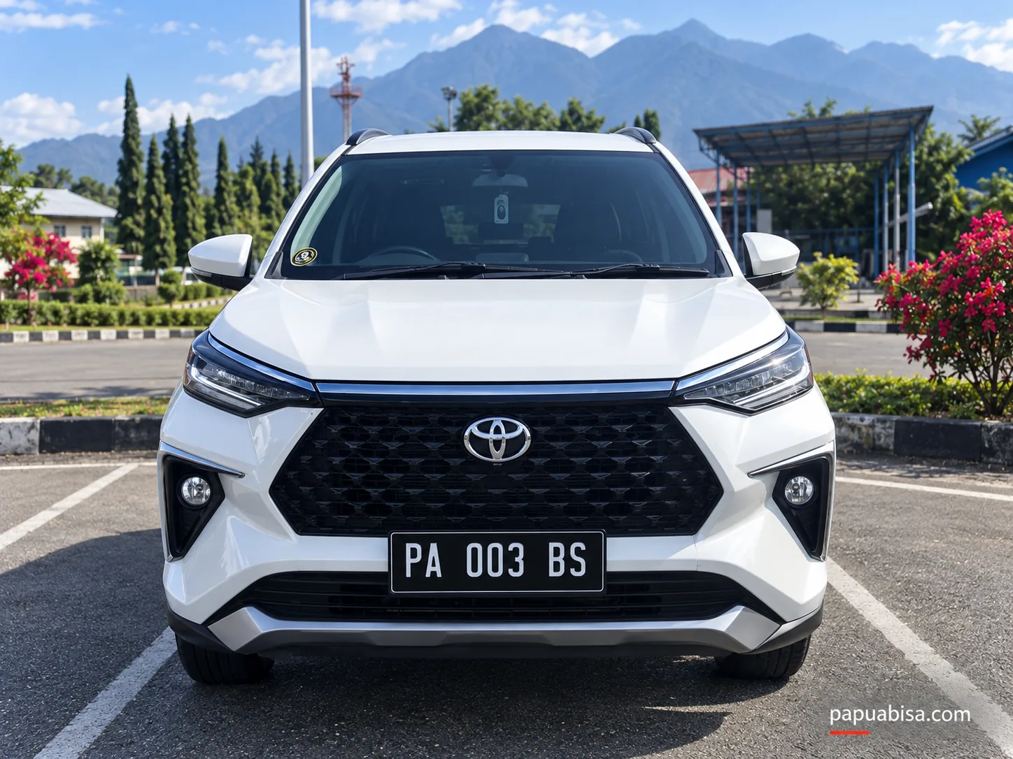 Unit Toyota putih di area parkir terbuka dengan latar pegunungan